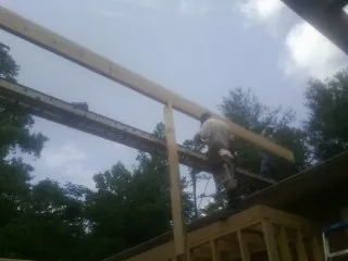 Carpenter setting a ridge beam over a new addition frame — Ice Dam Removal by Roofing Brothers in Myersville