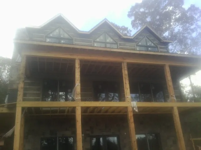 Dormers and porch framing on a large log home under construction — Roof Coating work by our crew in Myersville