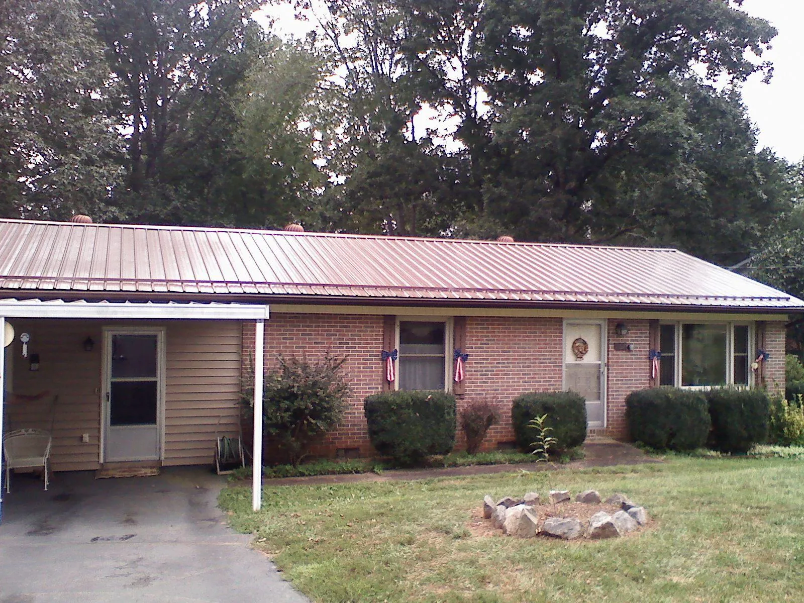 Bronze metal roof and carport on a brick ranch home — Roof Repair work by our crew in Myersville